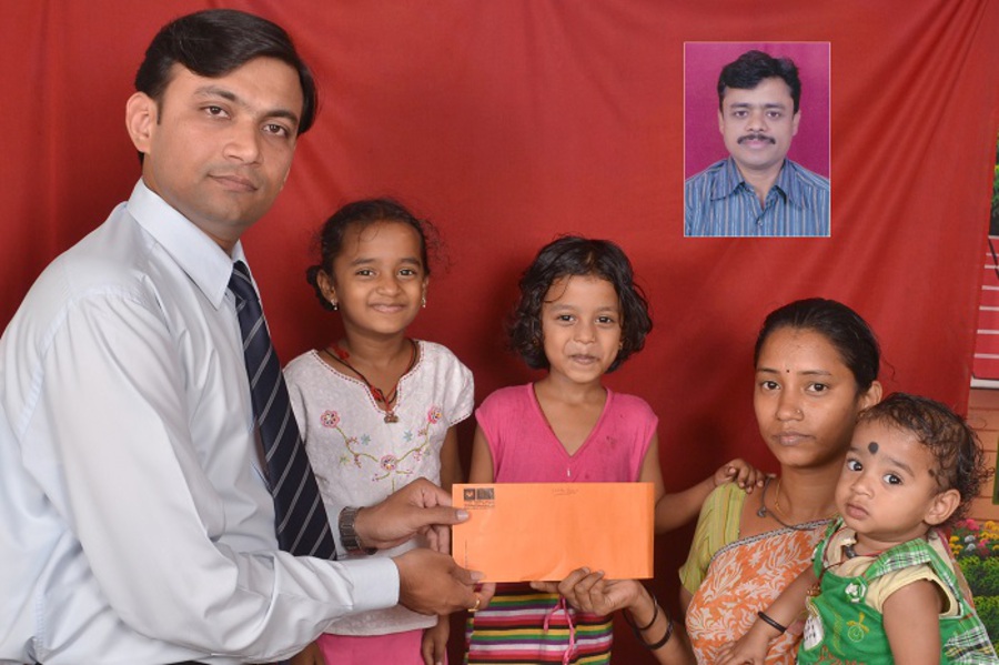 GIVING DEATH CLAIM CHEQUE TO A  FAMILY.